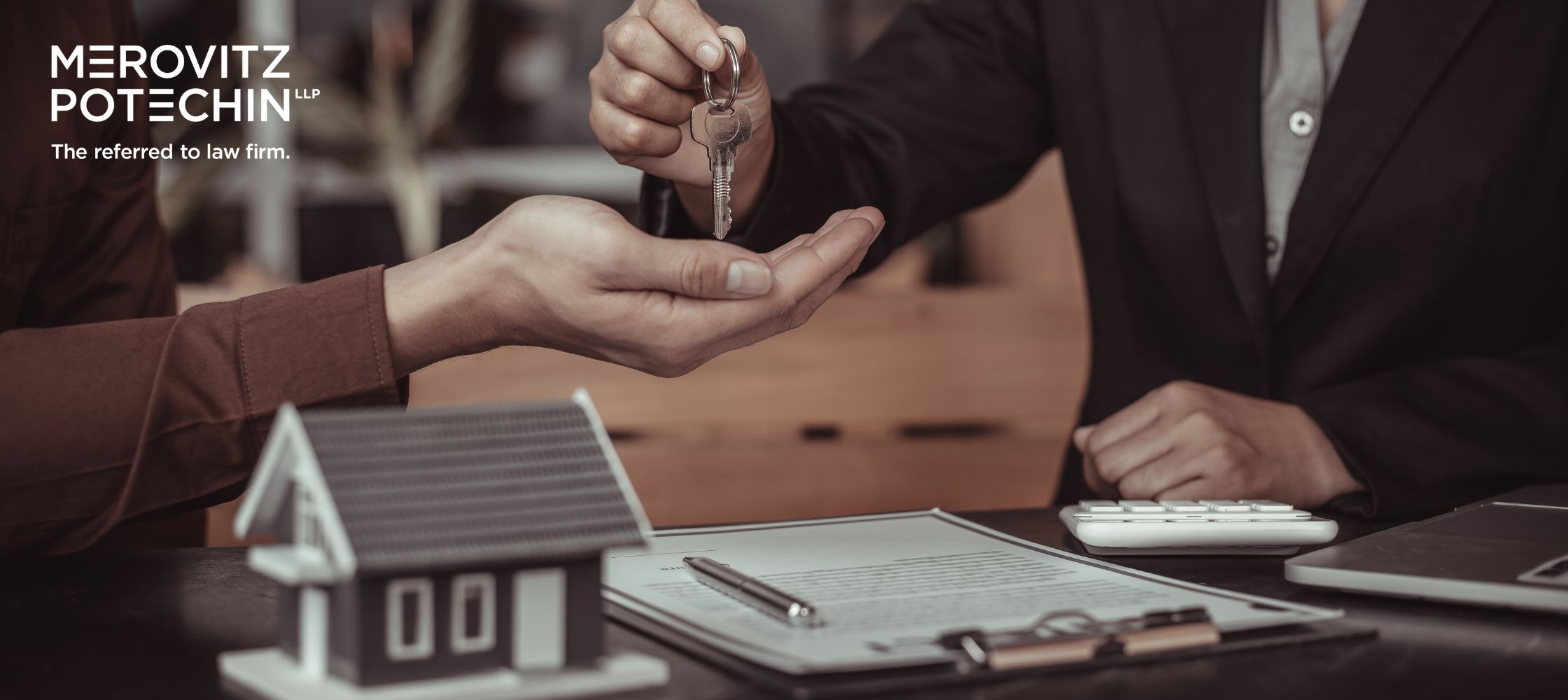 Buying property in Ontario, lawyer handing over house keys and reviewing legal documents for real estate transaction.
